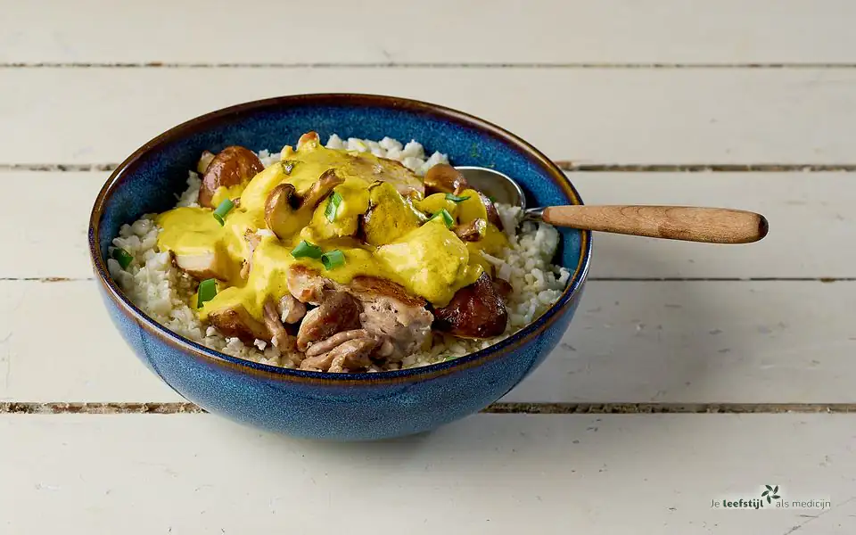 Curry van kippendij en kastanjechampignons met bloemkoolrijst