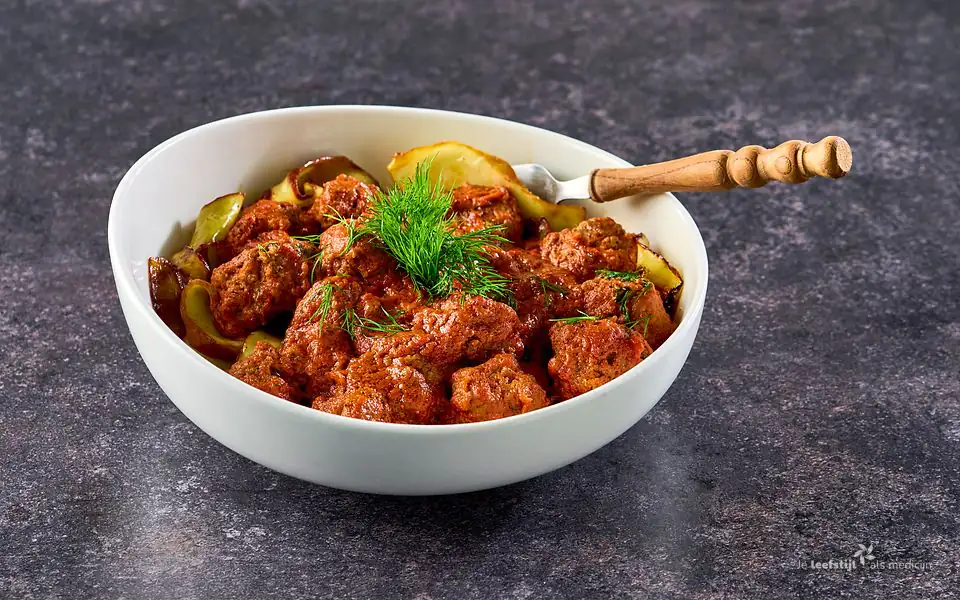 Gehaktballetjes in tomaten-roomsaus met kruidige witte kool