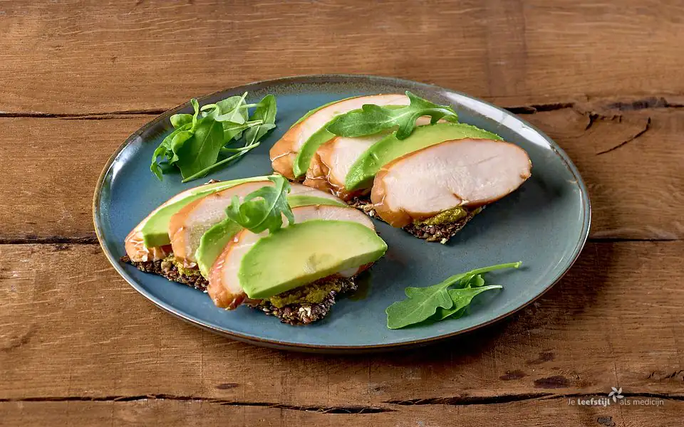 Lijnzaadcrackers met avocado, gerookte kip en pesto